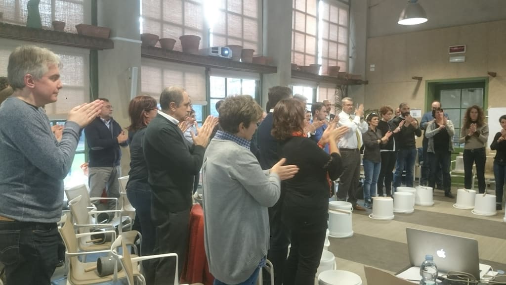 Partecipanti in piedi eseguono esercizi di body percussion