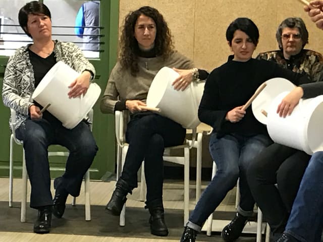 Partecipanti suonano i secchi