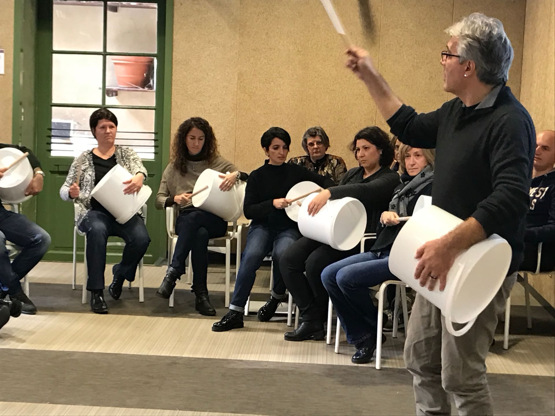 Stefano Corradi guida un gruppo di percussioni con i secchi durante un team building